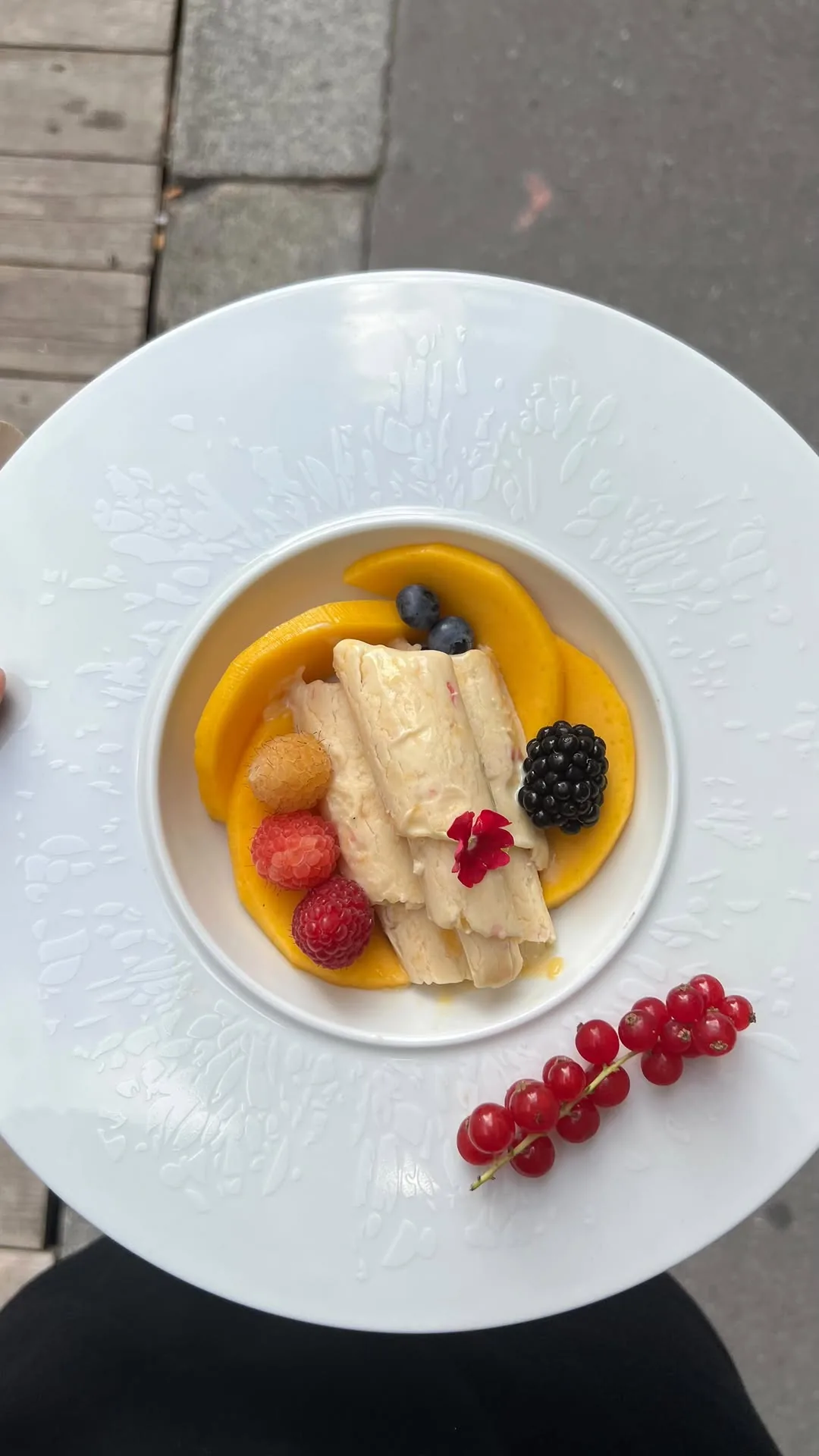 Création Marlotte : glaces roulées, mangue, baies et groseilles dans une assiette blanche